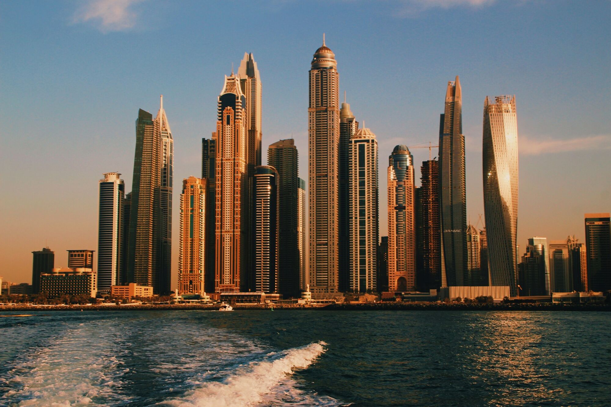 The Dubai Marina towers catching low sun, seen from the water on the way back in