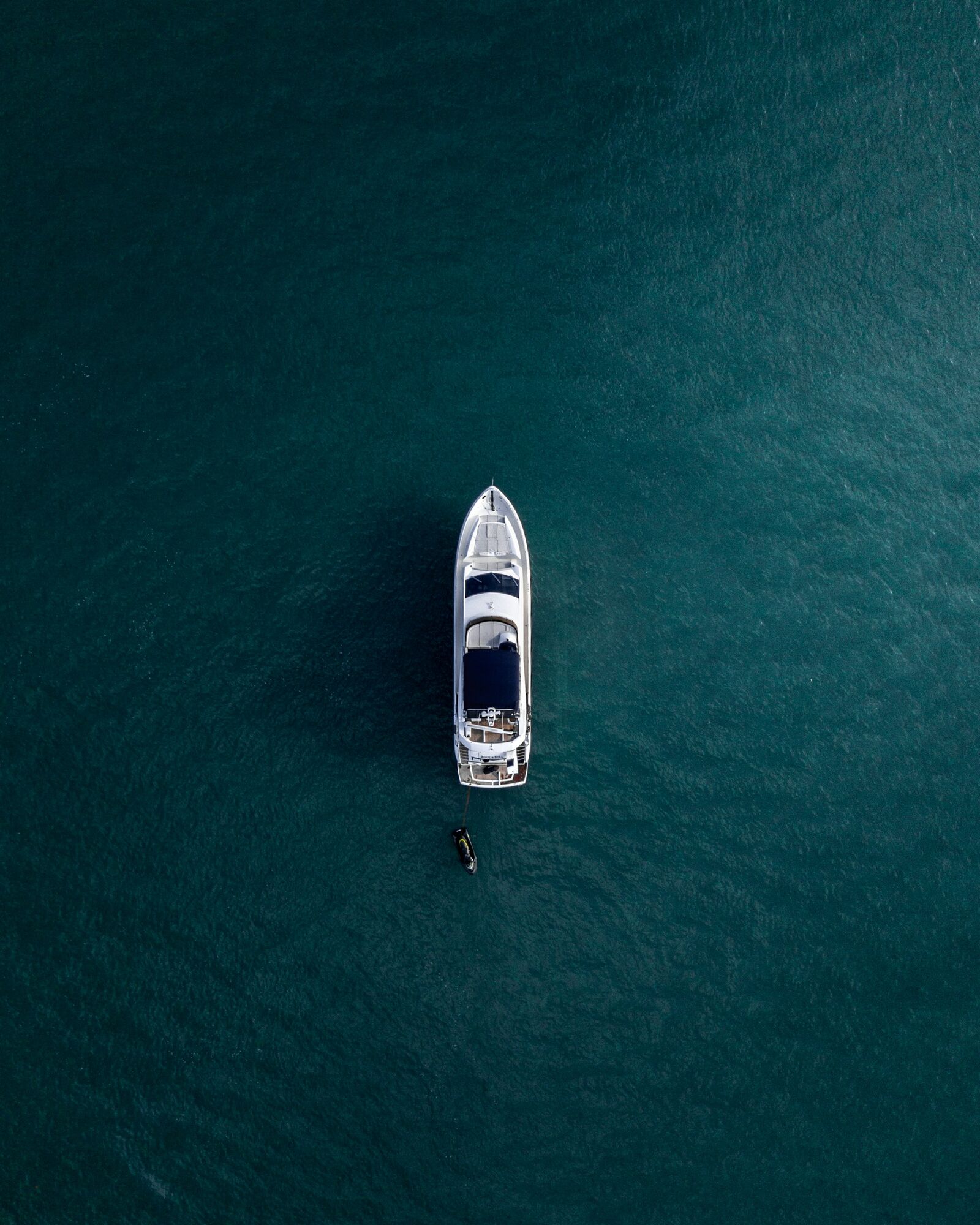 A yacht at anchor in clear water, seen from directly above at a swim stop