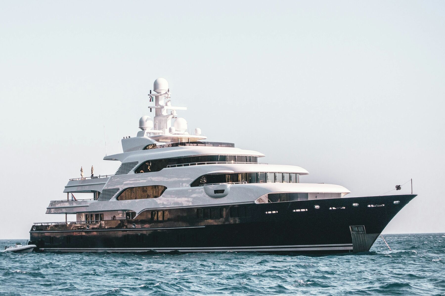 Gulf Royale at anchor, her dark hull and four decks side-on against a pale sky