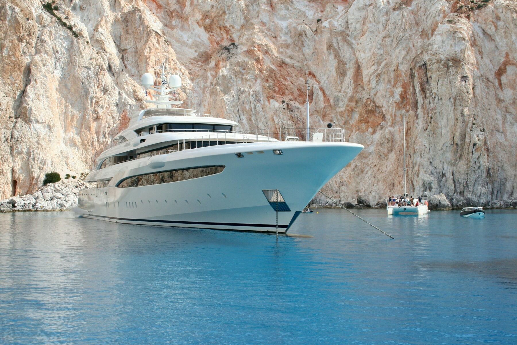 Marina Lyra lying quietly in sheltered water, her white hull mirrored on the surface