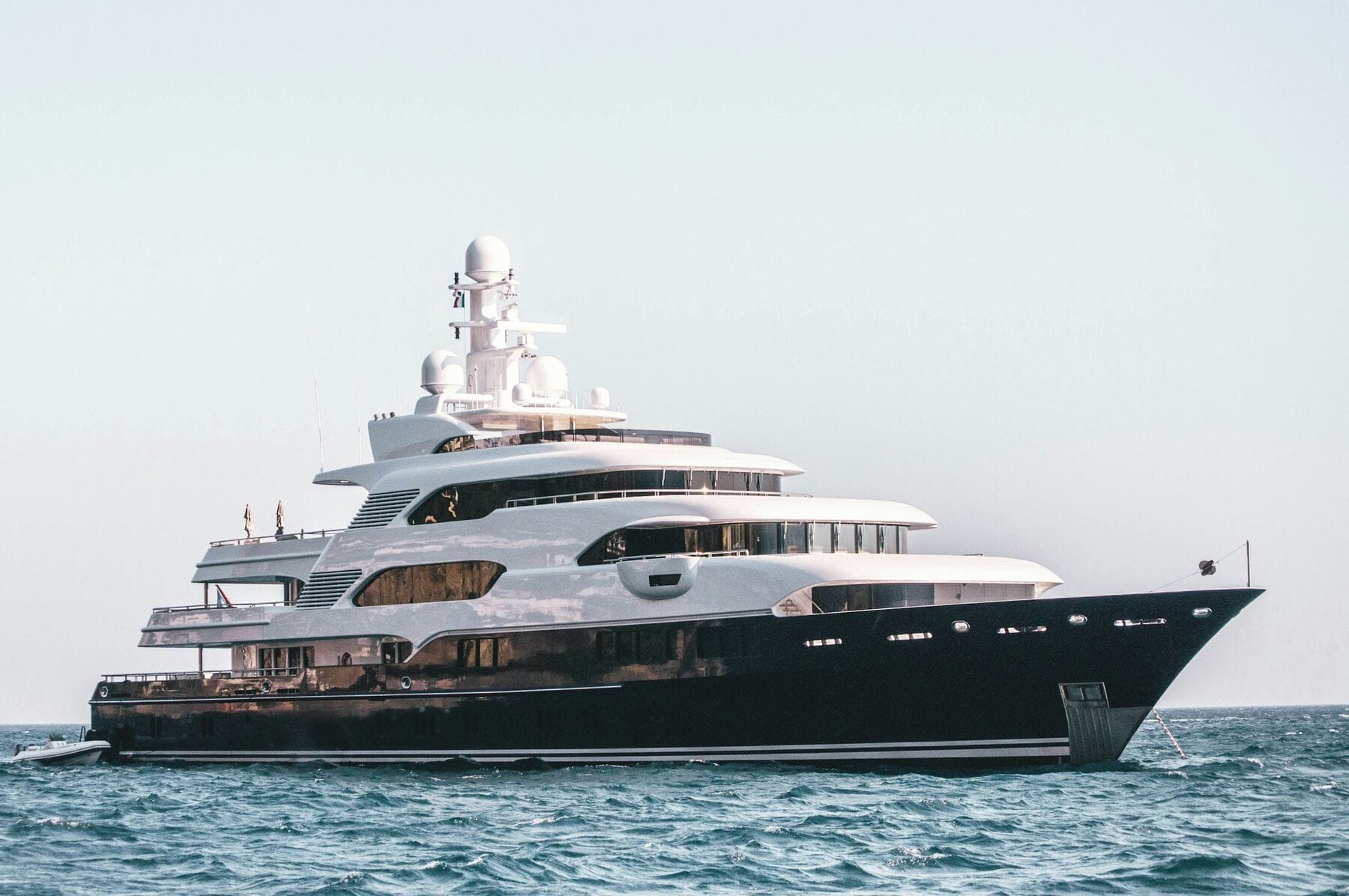 Gulf Royale at anchor, her dark hull and four decks side-on against a pale sky